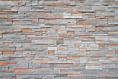 Gray, brown, red flat stone wall in a random pattern
