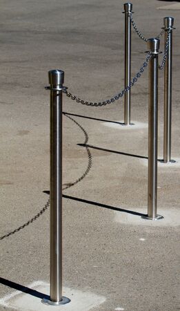 Stainless steel cue chain and posts on concreteの写真素材