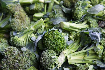 Pile of green broccoli at the farmers market with focus on center vegetable