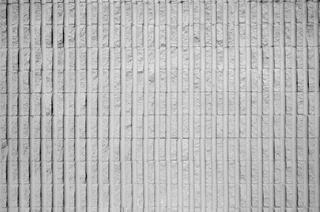 Gray concrete wall with vertical semi-cylinder shapes molded into blocksの写真素材