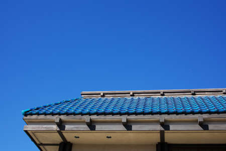 Asian style blue tile roof against cloudless skyの写真素材