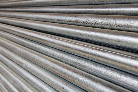 Pile of shiny galvanized steel pipe diminishing from right to left