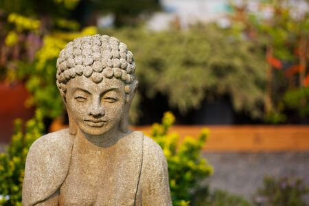 Shallow focus image of concrete Buddha  in an asian gardenの写真素材