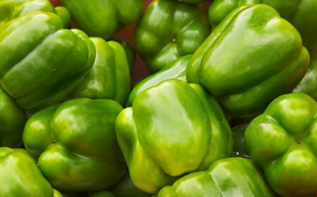 Green Bell Peppers at the farmers market with sharp focus on center vegetablesの写真素材