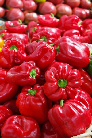 Pile of Red Bell Peppers at the farmers market with sharp focus on center vegetablesの写真素材