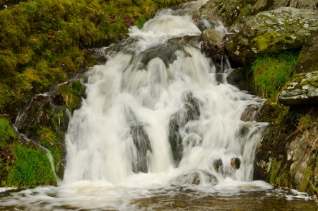 Water forming small waterfalls in a mountain stream