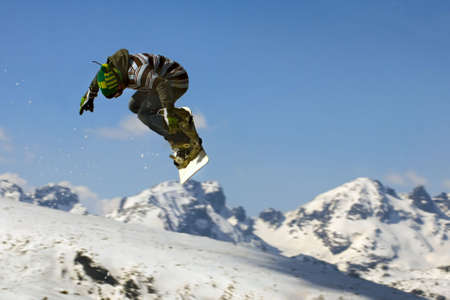 Snowboarder  jumping over the snow-mountain. の写真素材