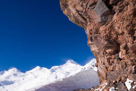The red volcanic rock against the backdrop of mountain peaksの写真素材