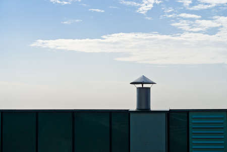 The ventilation pipe on the roof of a building on a background of skyの写真素材