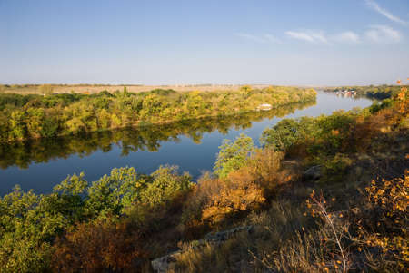 The autumn banks of the river with reflections in waterの写真素材