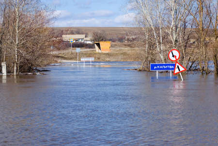 Spring flood on the Kalitva river, Rostov region, Russia. The road is flooded with water. Road markings are barely visible due to high water levelsの写真素材