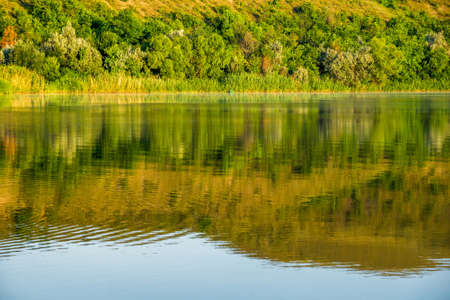 Morning on the Seversky Donets River near the town of Belaya Kalitva. The high and steep right bank is beautifully distorted in the water of the riverの写真素材