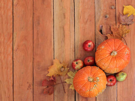 Autumn still life with pumpkins, leaves and apple on old wooden background, top viewの写真素材