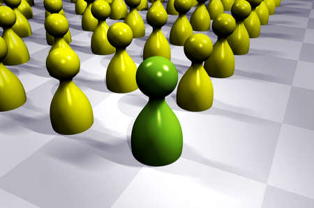 Green game figurine standing out in a group of yellow ones, symbolizing leadership, infinite depth of fieldの写真素材