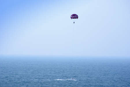 Parachute and cutter on seaの写真素材