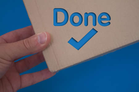 Done text with Checkmark with cardboard box. Brown folded cardbox.の写真素材