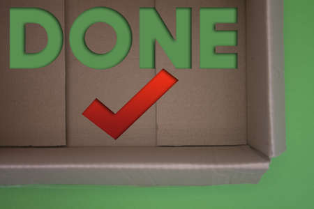 Done text with Checkmark with cardboard box. Brown folded cardbox.の写真素材