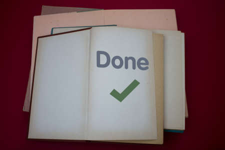 Done text with Checkmark in opened book with vintage, natural patterns old antique paper design.の写真素材