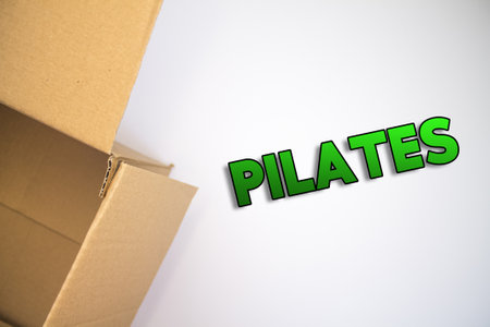 Pilates word with cardboard box. Brown folded cardbox.