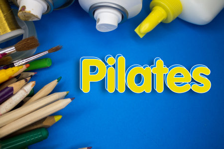 Overhead shot of school supplies with Pilates text. Brushes, pencils, artistic tools. Art And Craft Work Tools.の写真素材