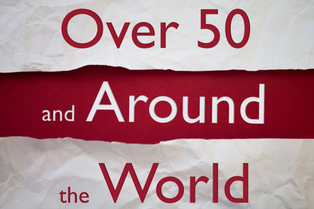 Over 50 and around the world text with Torn, Crumpled White Paper on colored background.