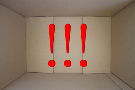 Exclamation mark word with cardboard box. Brown folded card box.の写真素材