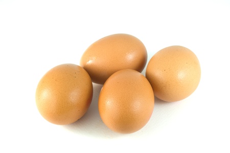 four eggs lying down on a white linen backgroundの写真素材