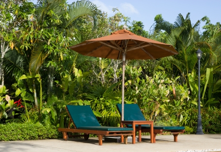 Swimming pool with relaxing seats and sun umbrellaの写真素材