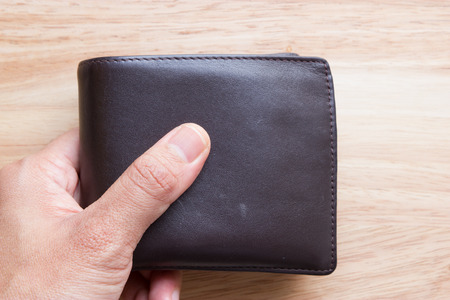 Brown leather wallet on wood