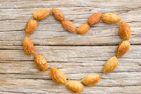 Heart of almonds on woodの写真素材