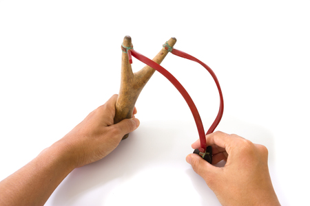 Hand pulling catapult slingshot isolated on white backgroundの写真素材