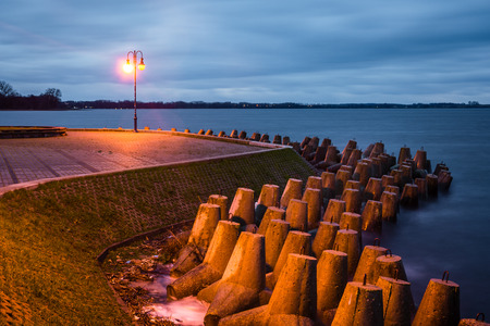 Breakwater near the Niegocin lake and rainy clouds at night in Gizycko, Masuria, Polandの写真素材