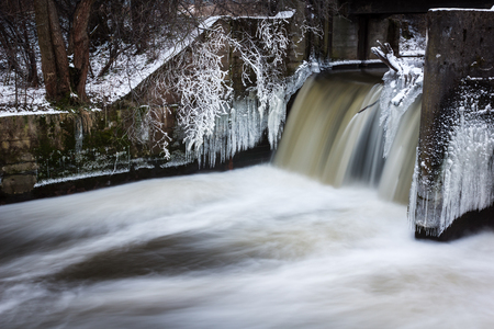 Dam on the Jeziorka river and moving water at winter, Polandの写真素材