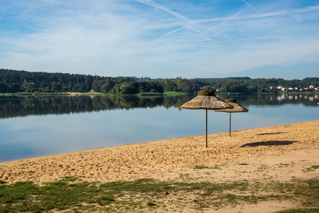 Umbrellas on the beach over the Brodzkie lake near Krynki, Swietokrzyskie, Polandの写真素材