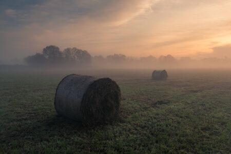Sunrise over bales of straw in the Jeziorka valley near Piaseczno, Polandの写真素材