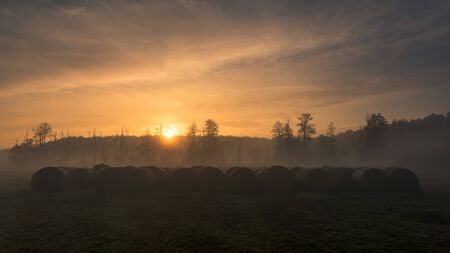 Sunrise over bales of straw in the Jeziorka valley near Piaseczno, Polandの写真素材