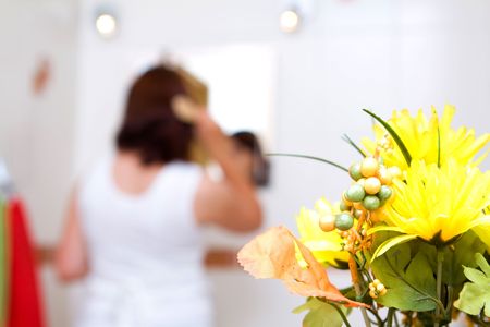 Woman in the mirror drying hairの写真素材