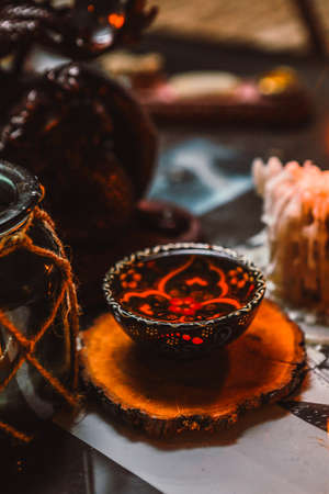 Chinese tea in colorful in tea bowl handmade ceramics with painting on wooden coaster, tea ceremony, blurred backgroundの写真素材