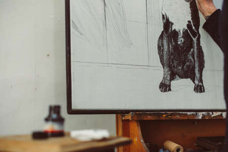Distance view of drawing with ink pen, monochrome picture of dog on canvas on easelの写真素材