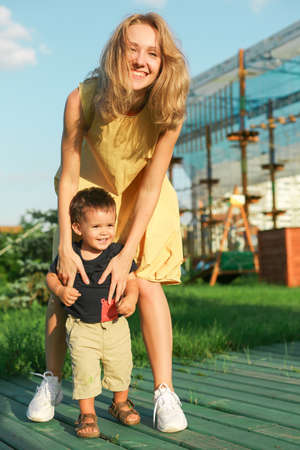 warm sweet portrait of young happy woman touching little boy, both are smiling