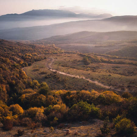 Picturesque landscape of colorful autumn forrest and foggy mountainsの写真素材