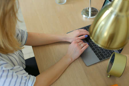 top view of woman working at the laptop at the wooden table