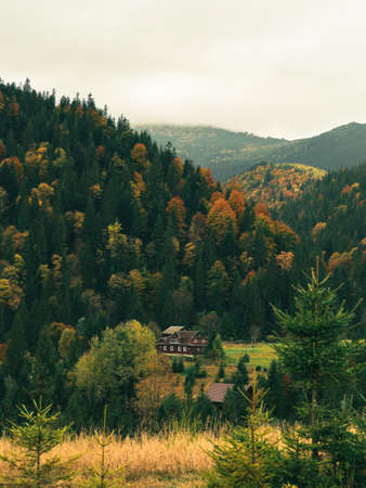 Autumn landscape in the Carpathian mountains. Wooden house on a hillside in the forest.の写真素材
