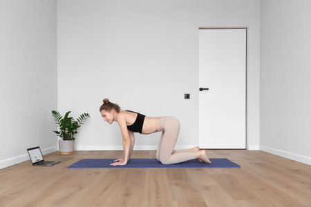 young woman is watching online sport class at home