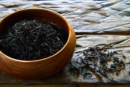 Dried tea in wooden dish on the table