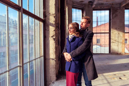 Couple stands near large window on construction siteの写真素材
