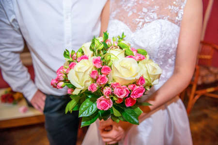 Wedding bouquet in bride hands with groomの写真素材