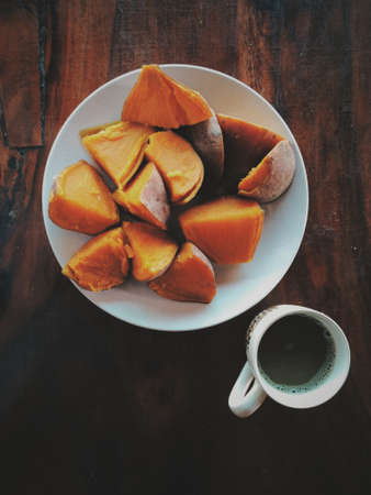 Lunch break, Sweet yams and coffee on table. Top viewの写真素材