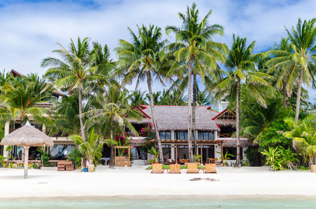 Luxury tropical villa near the sea with beautiful colourful decor surrounding palm trees and lounges...