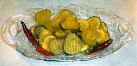 A glass plate with pepper flavored bread and butter picklesの写真素材